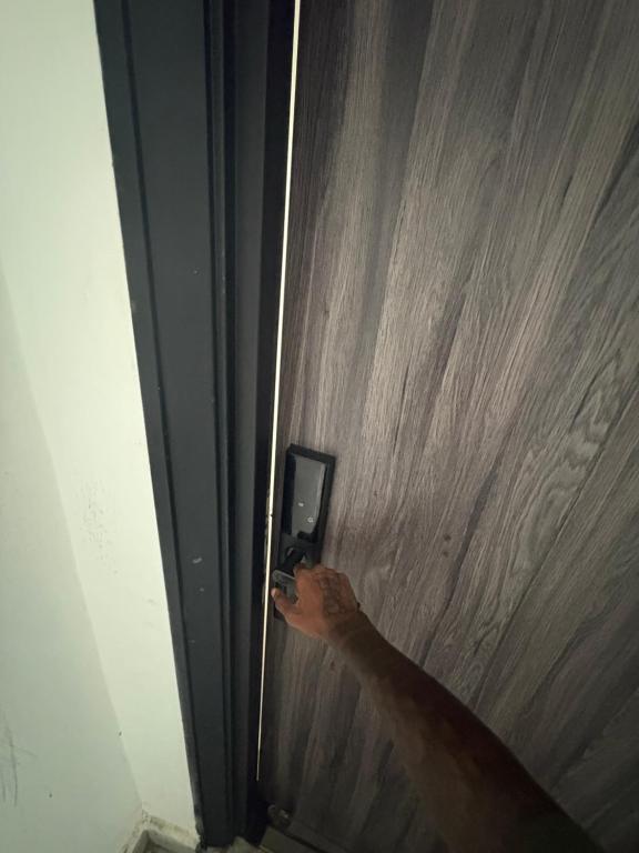 a person holding a cell phone in front of a wall at 2bedroom luxury apartment in Lekki