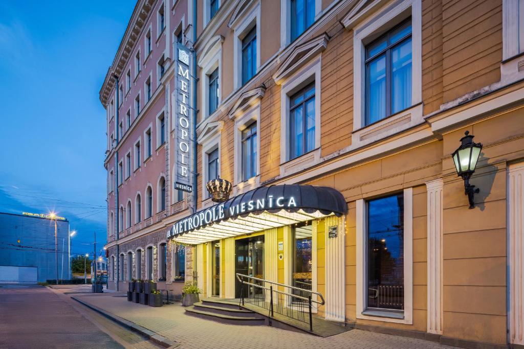un edificio con un cartel para una tienda en una calle en Eurostars Metropole, en Riga