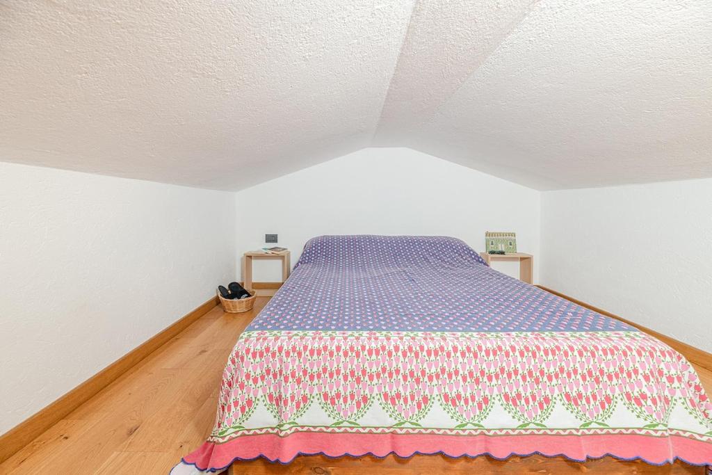 a bedroom with a bed with a colorful blanket on it at Nest-home in front to Mont Blanc in Courmayeur