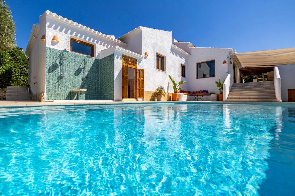 a villa with a swimming pool in front of a house at Ca Rulleta Jávea in Jávea