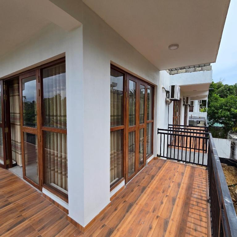 a balcony of a house with wooden floors and windows at Waypoint Resort and Apartments in Hikkaduwa