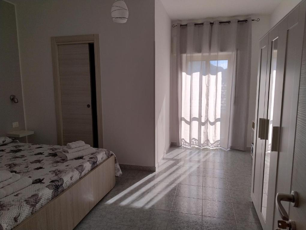 a bedroom with a bed and a large window at La Casa Di Nonna Lucrezia in Orsomarso