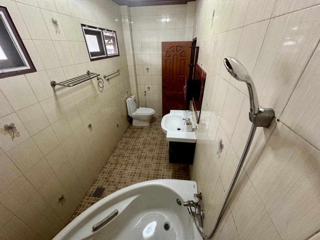 a bathroom with a toilet and a sink and a urinal at Yoga Bed and Breakfast in Chiang Mai