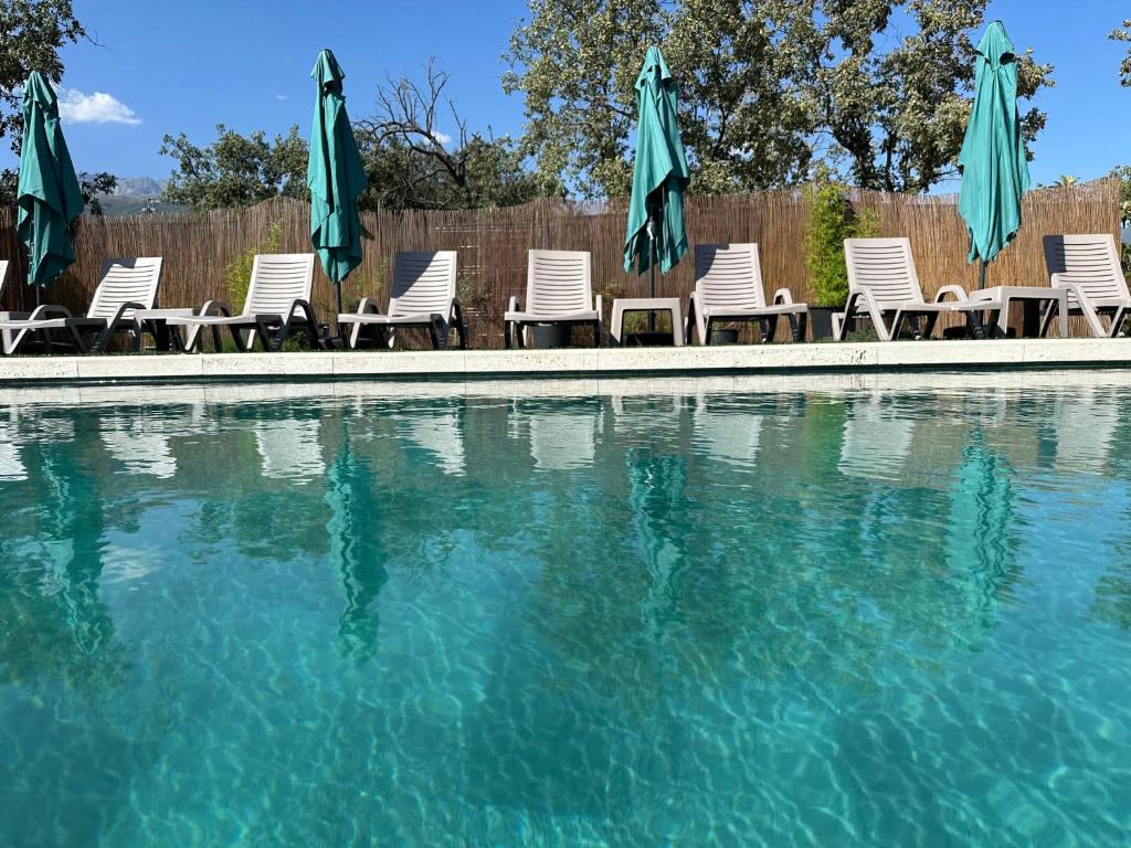 a group of chairs and umbrellas next to a swimming pool at Los Royares in Candeleda