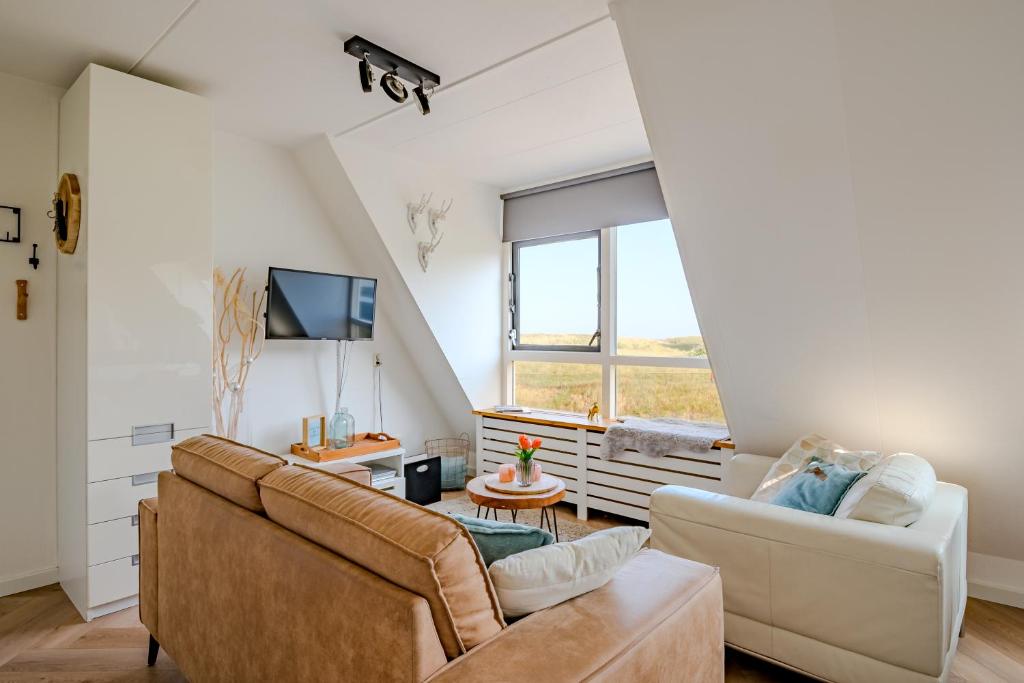 a living room with two couches and a tv at Perfect Stay Holiday, Sea View in Egmond aan Zee