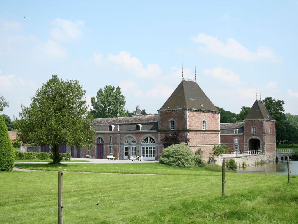 una vecchia casa in mattoni con un ampio cortile di Holiday home for 10 people set in castle grounds a Barvaux-Condroz