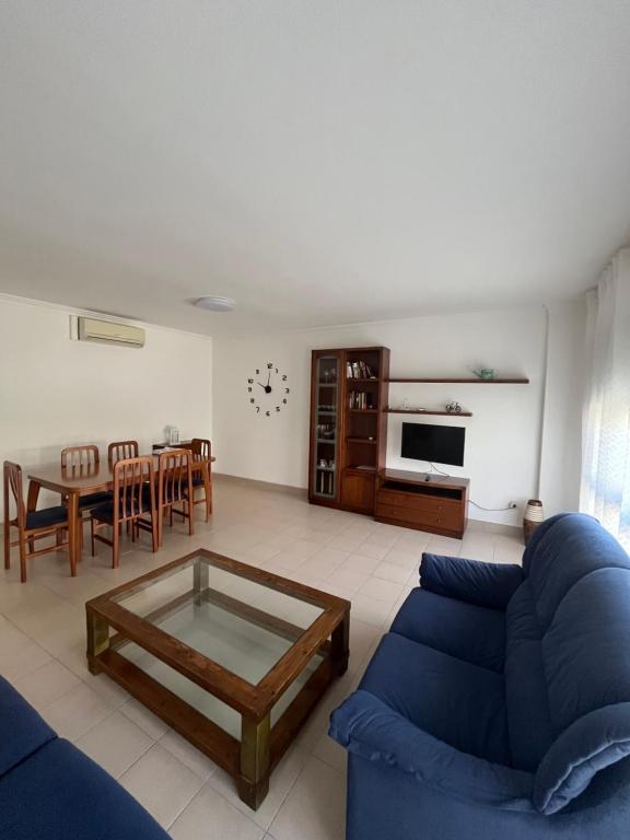 a living room with a blue couch and a table at Vacaciones en la playa in Sant Carles de la Ràpita