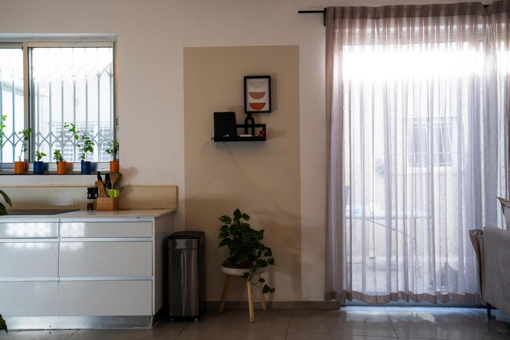 a kitchen with a white dresser and a window at Casa brisa in Tel Aviv