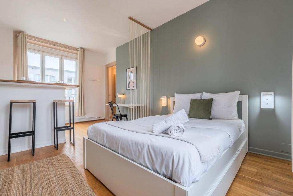 a bedroom with a large bed and a table at Grand Place very well located studio in Lille