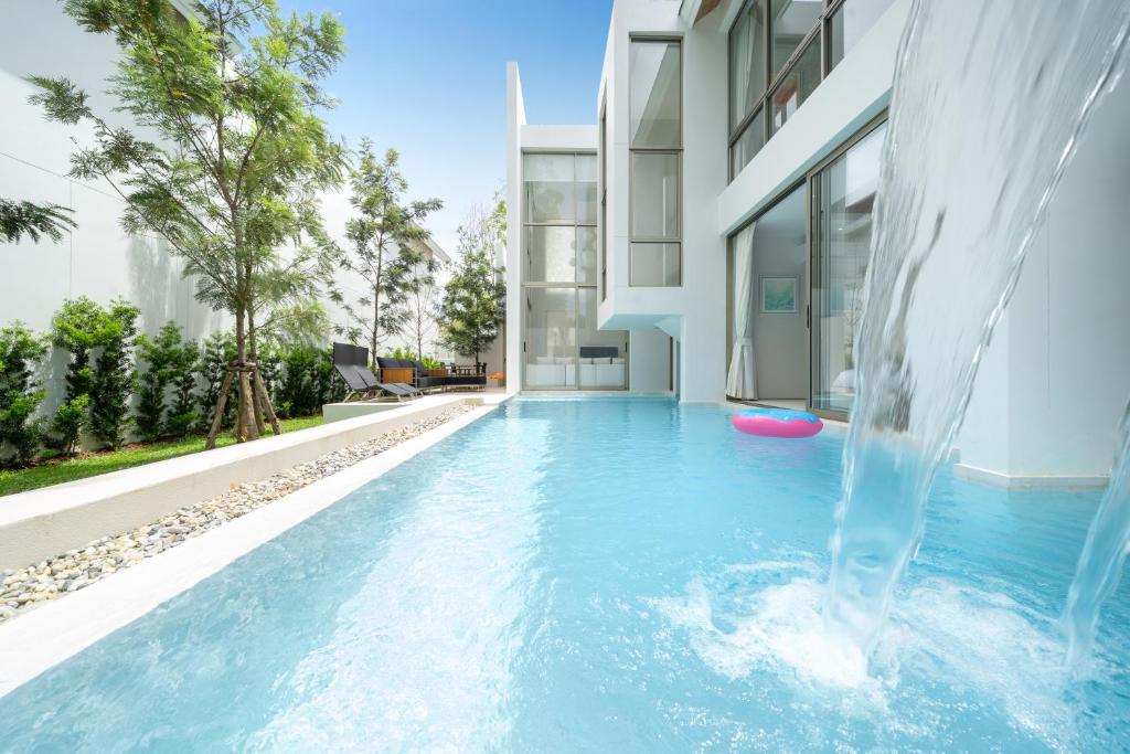 a swimming pool with a water slide in front of a building at Elegant Nature villa with Private Swimming pool in Phuket Town