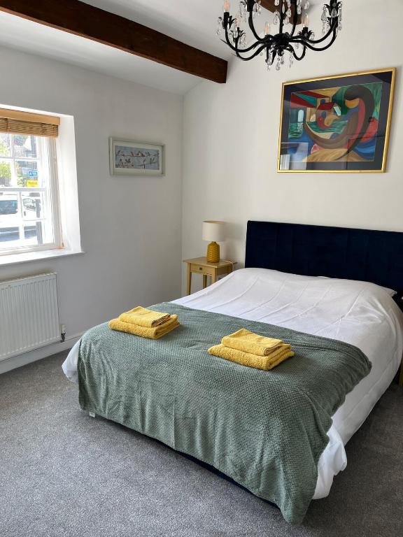 a bedroom with a bed with two yellow towels on it at Railway Cottage Horsforth in Horsforth