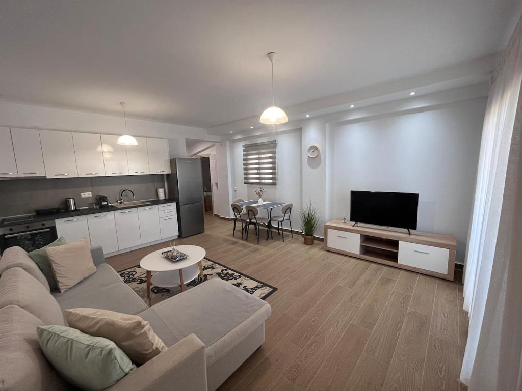a living room with a couch and a kitchen at Fred apartment in Nea Fokea