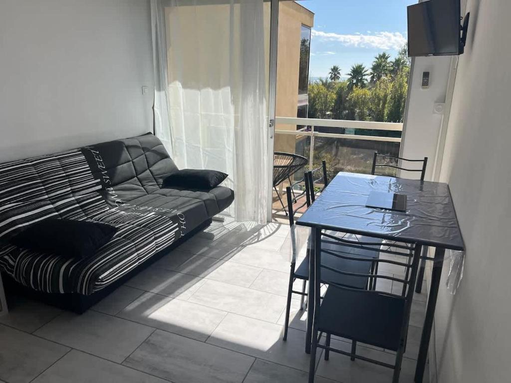 d'un salon avec un canapé et une table ainsi que d'un balcon. dans l'établissement Charmant Studio Proche Plage, à Valras-Plage