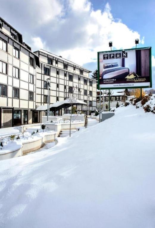 a snow covered street in front of a building at Apartman Iva Brzeće-Kopaonik in Brzeće