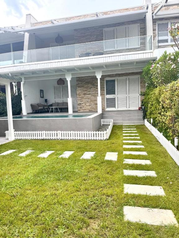 ein Haus mit einem Rasen davor in der Unterkunft Crystal Pool Villa Bay of Lalzi in Draç