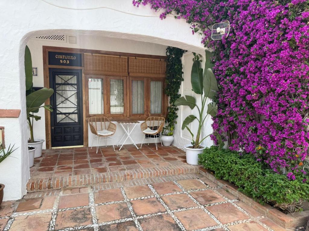 an entrance to a house with purple flowers at El Cortijillo 503 in Almuñécar