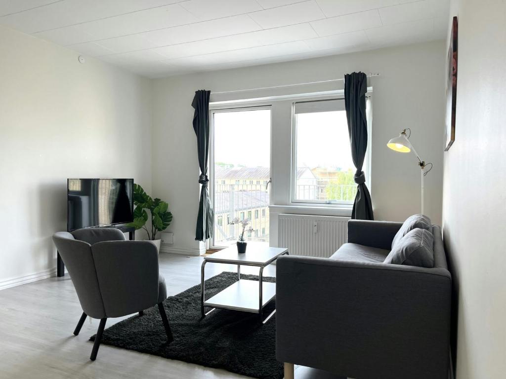 a living room with a couch and chairs and a window at Spacious Apartment for 4 in Aalborg