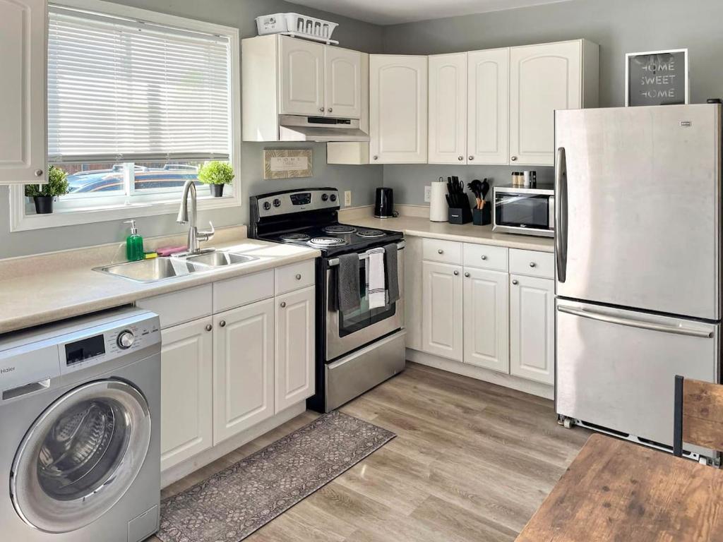 a kitchen with white cabinets and a white refrigerator at Cozy Retreat with Netflix and Work Desk in Fort Erie