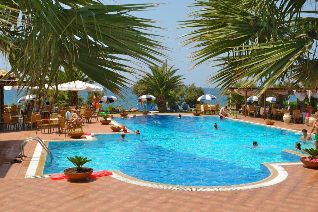 a large swimming pool with people in the water at Hotel Oasis in Kyparissia