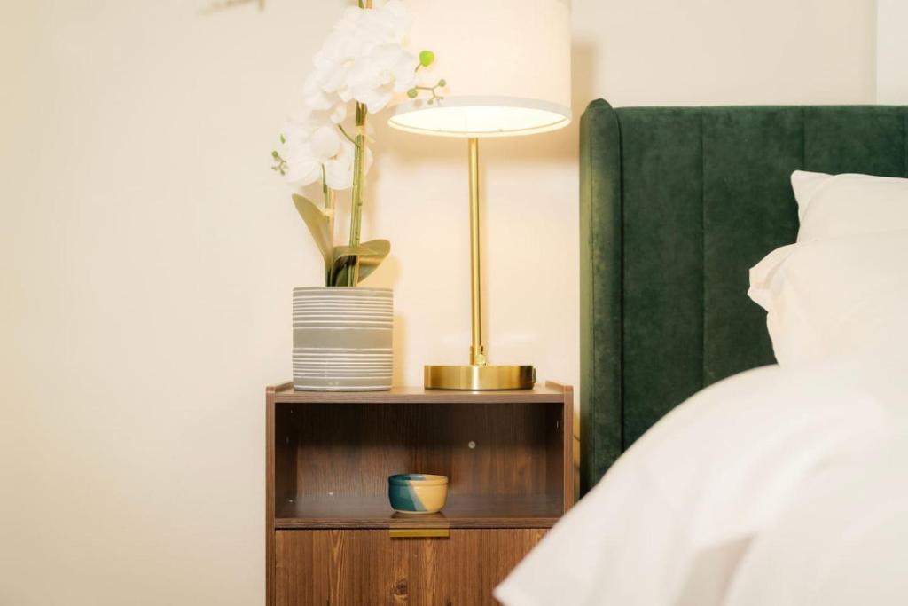 een nachtkastje met een bed en een lamp erop bij Heights Haven on Paris - 2BD Stay in Peoria Heights