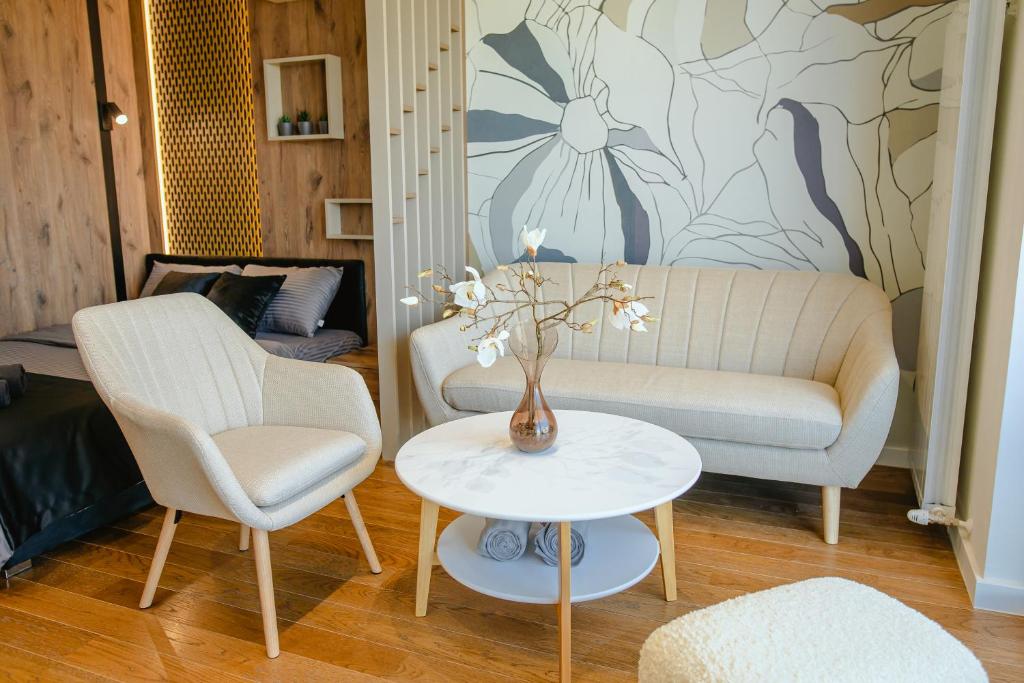 a living room with a couch and a table and chairs at Luna Residence in Niš