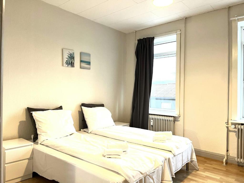 two beds in a room with a window at Spacious Apartment for 6 in Frederikshavn