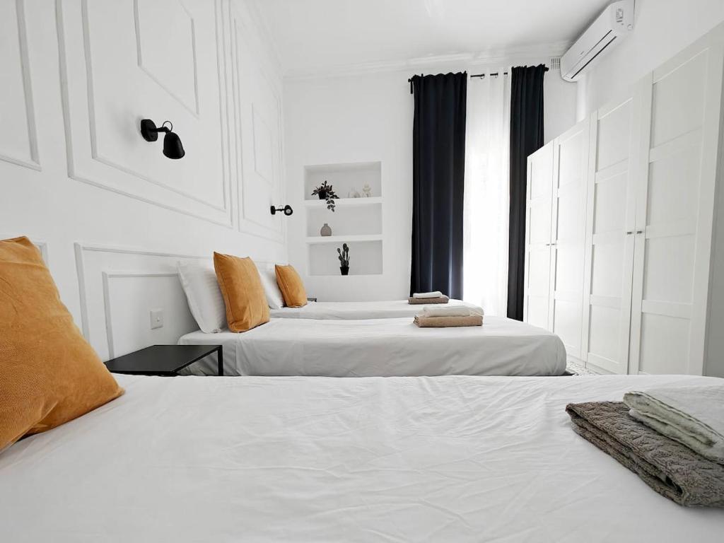 two white beds in a white room with a window at Cosy Room 8 in Tal-Pietà