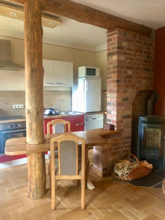 a kitchen with a wooden table and a brick fireplace at Eulenwohnung Apartment in Gommern