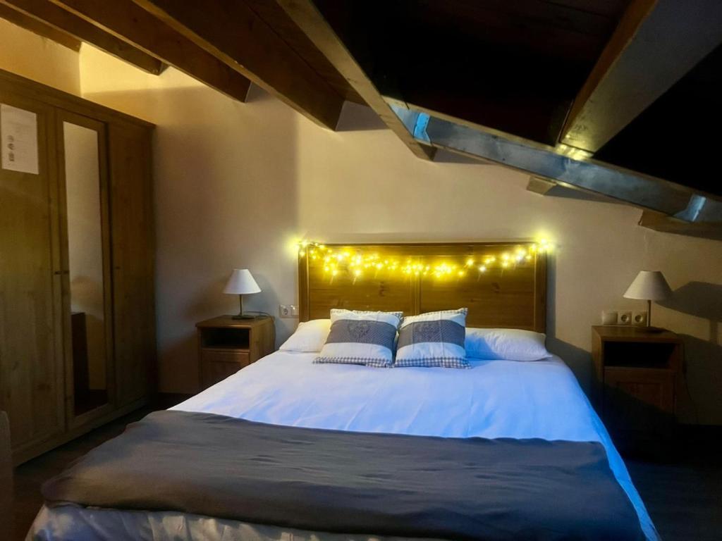 a bedroom with a large bed with lights on it at La Caseta del Pont in Camprodon