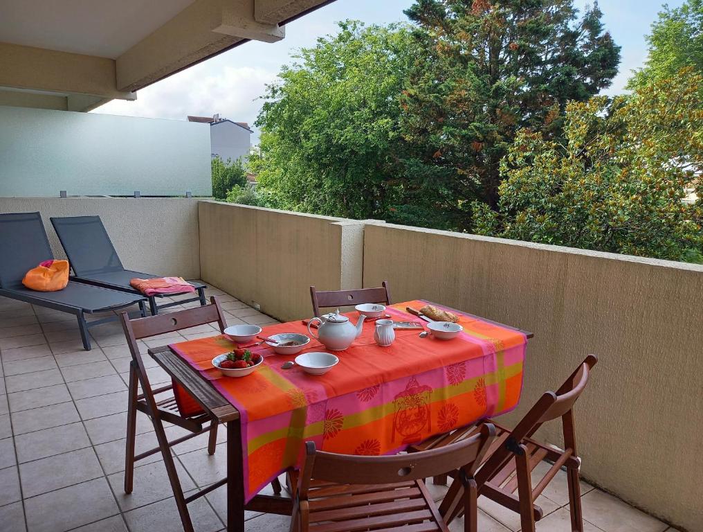une table avec un tissu de table coloré sur une terrasse dans l'établissement Charmant appartement bord de mer, à Arcachon