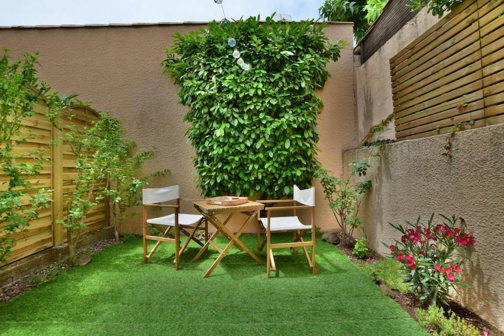 a garden with a table and chairs on the grass at Pavillon 4-6 couchages in Cap d'Agde