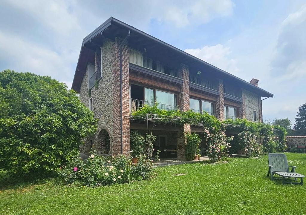 a brick house with a bench in the yard at B&B Il Posto delle Rose in Almenno San Salvatore