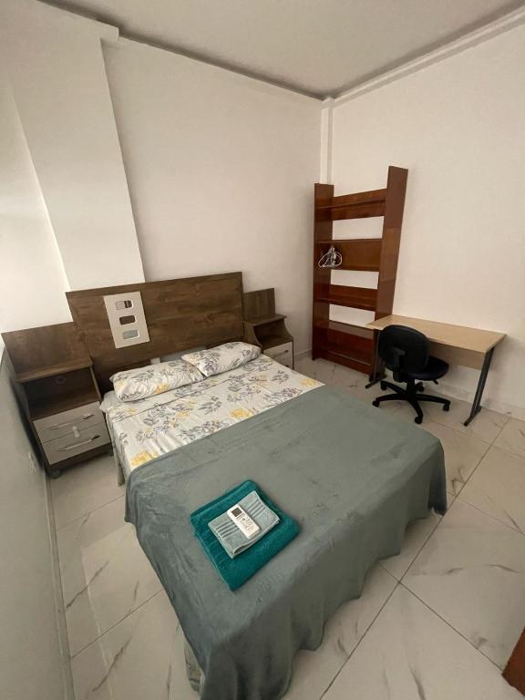 ein Schlafzimmer mit einem Bett, einem Schreibtisch und einem Stuhl in der Unterkunft Studio Centro do Rio in Rio de Janeiro
