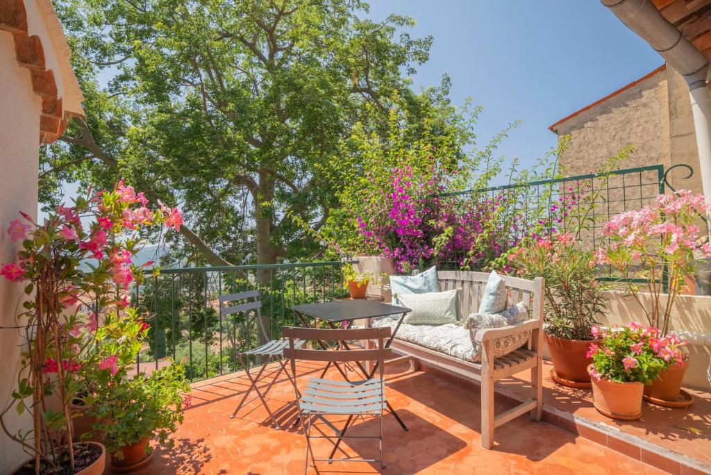 une terrasse avec un canapé, des chaises et des fleurs dans l'établissement Lilie House, à Bormes-les-Mimosas
