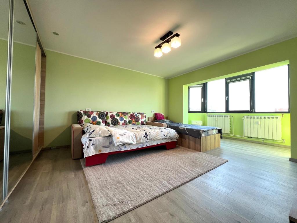 a bedroom with a bed in a room with green walls at SouthBrise Apartments - Garsoniera Mangalia - 100m de plajă in Mangalia