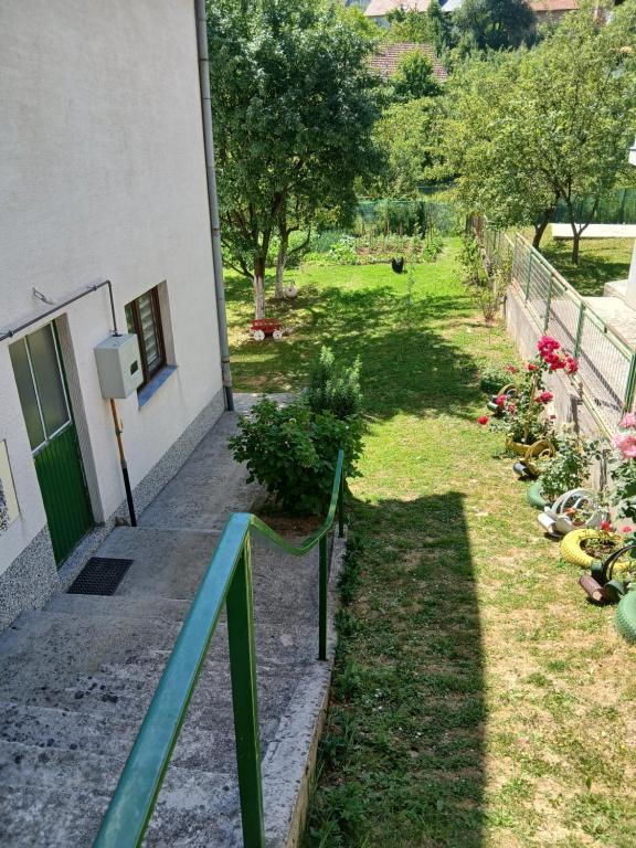 a building with a green railing next to a yard at Rooms-Zejnep SARAJEVO in Sarajevo
