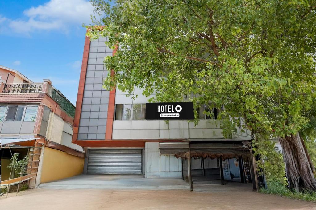 a large building with a mieo sign on it at Super Hotel O Villivakkam Railway Station Formerly BV Stayz in Chennai