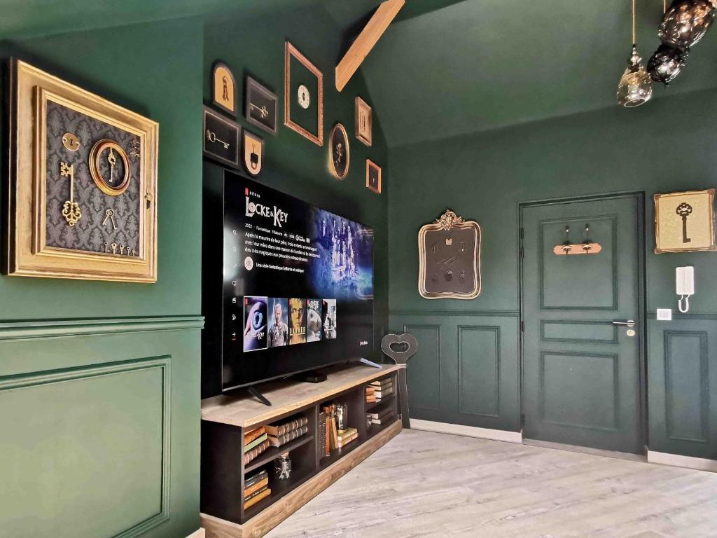 圣洛LES CLES DES REMPARTS - Appartement privé à thème tout équipé - Atypique - Centre Saint-Lô - Gare - Haras - Parking public gratuit - Entrée autonome - Wifi - Netflix - TV XXL - Lit 160x200的客厅设有绿色的墙壁和电视。
