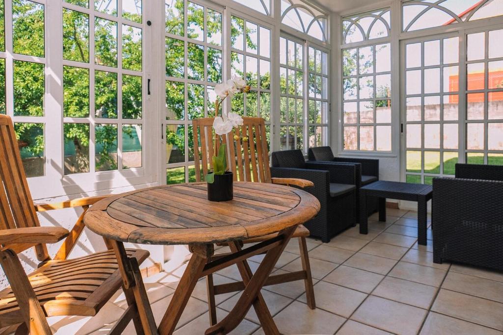 ein Raum mit Tisch und Stühlen und Fenstern in der Unterkunft Bella y cálida cerca de Vigo by CABANA Rentals in Vigo