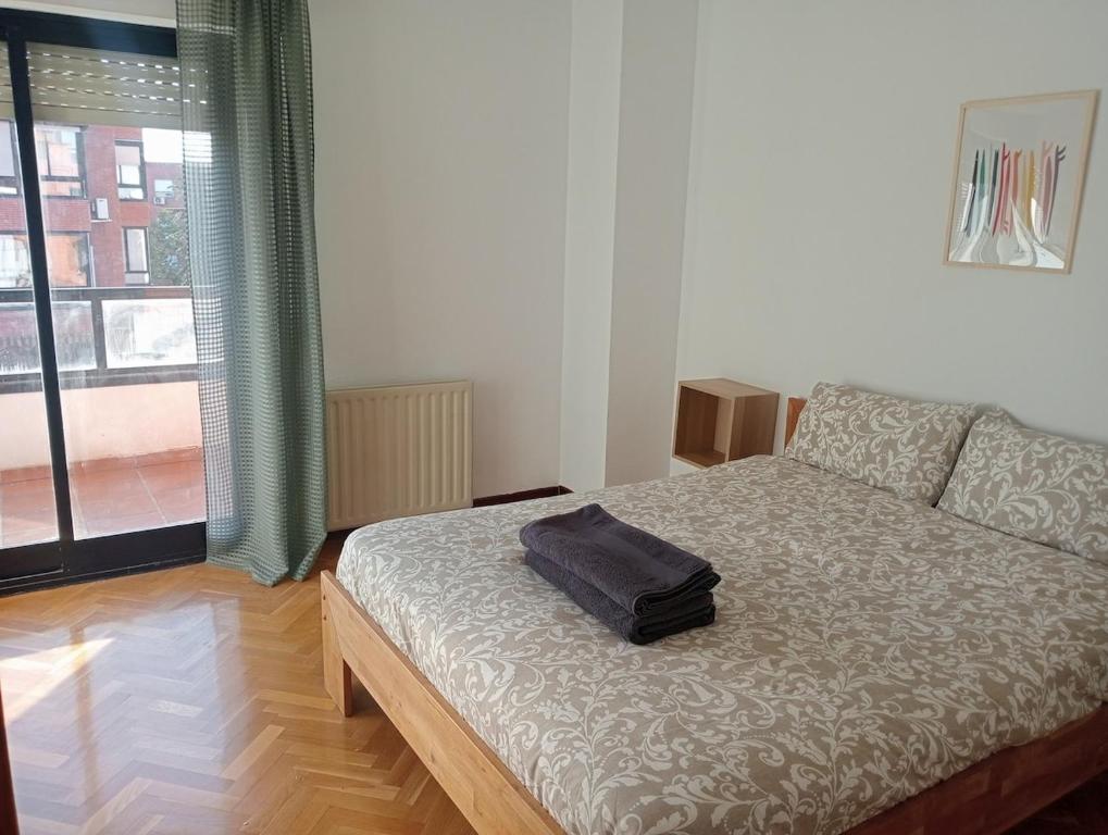 マドリードにあるApartmento con parking Madrid barajas ifema metropolitanoのベッドルーム1室(ベッド1台、バッグ付)