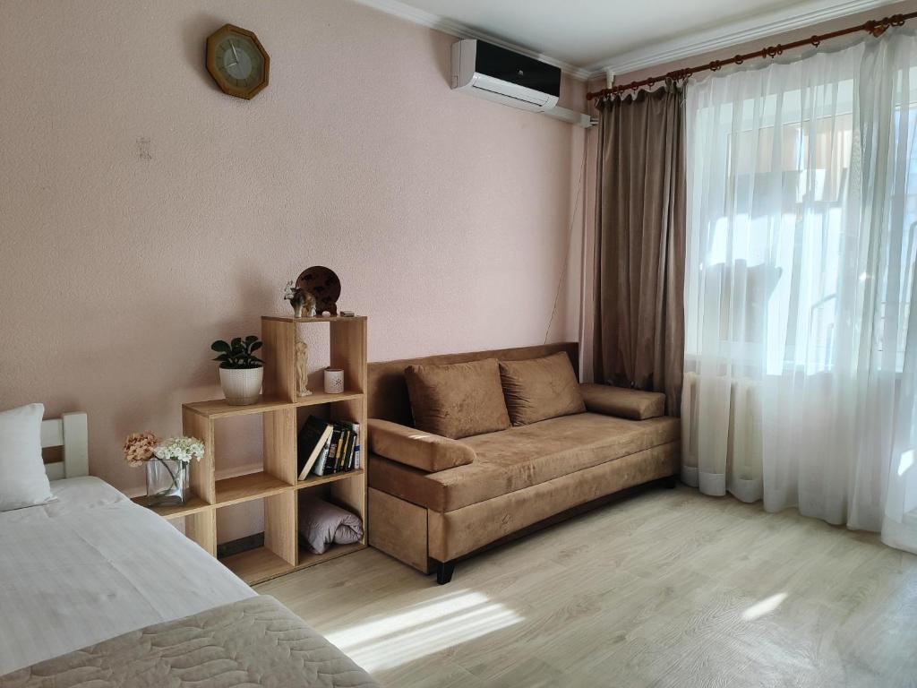 a living room with a couch and a bed at Однокімнатна на Троєщині in Kyiv