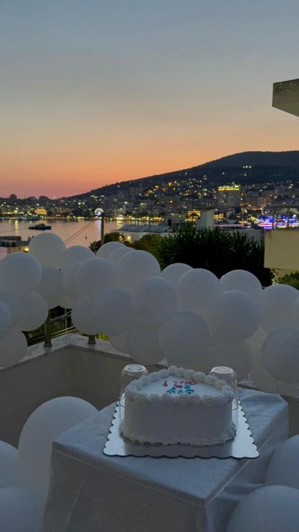 a white cake sitting on a table with white decorations at Hotel Barjami in Sarandë