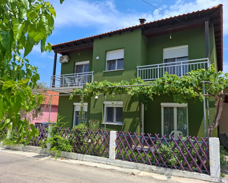 a green house with a fence in front of it at Olivendra Thassos in Prinos