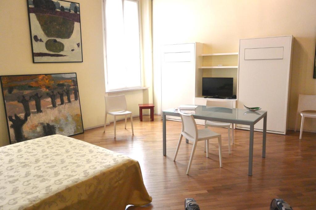 Zimmer mit einem Tisch, Stühlen und einem TV in der Unterkunft Residence Alcorso in Mantua