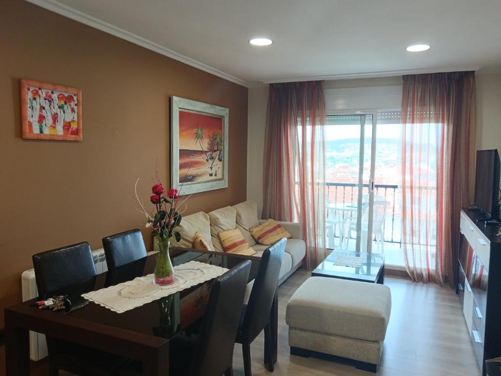 a living room with a table and a couch and a dining room at Apartamento Perla 2000 in Portonovo