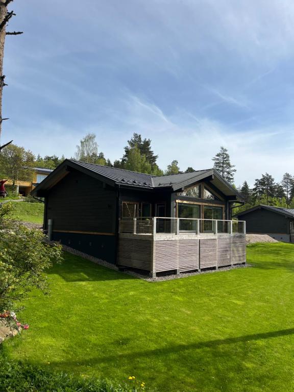 a black house with a deck on a lawn at Kiiski Home in Teijo
