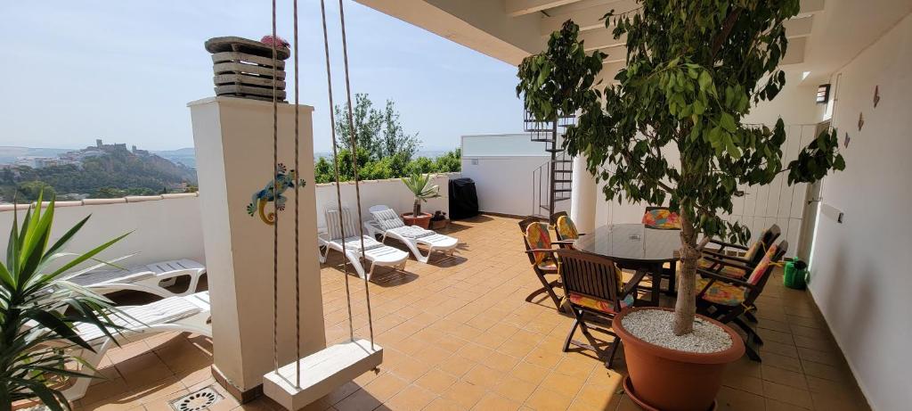 アルコス・デ・ラ・フロンテーラにあるAtico Arcos Terraza Relaxのバルコニーにテーブルと椅子が置かれたパティオ