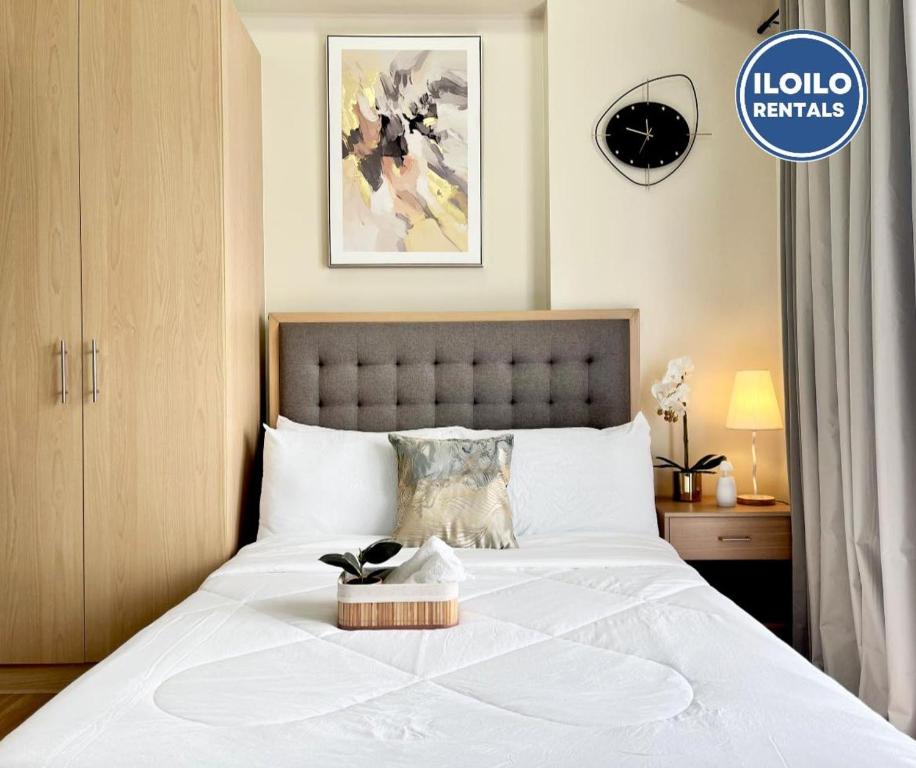 a bedroom with a large white bed with a box on it at Modern Studio in Saint Dominique in Iloilo City