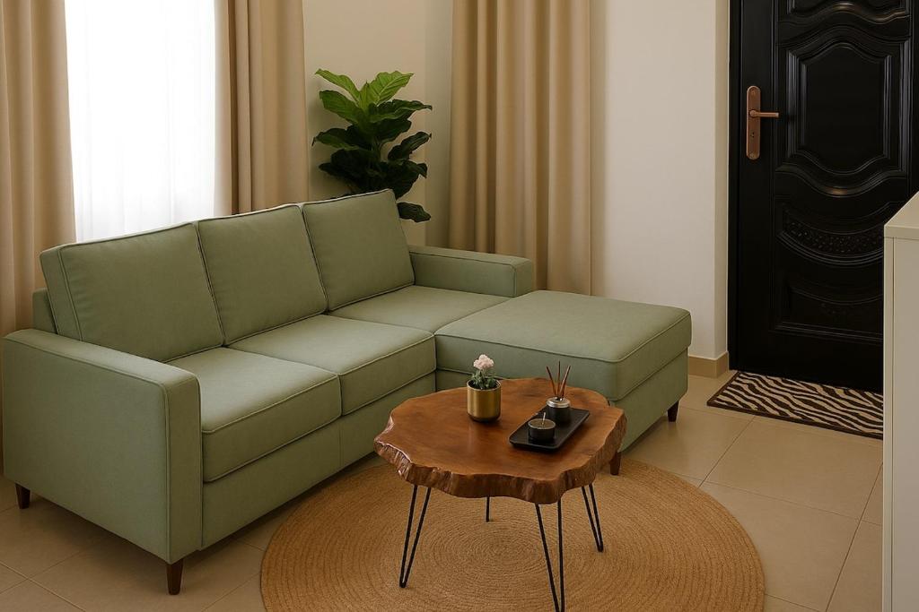 a living room with a green couch and a coffee table at Peaceful Retreat for Drivers Near Arusha Park in Usa River