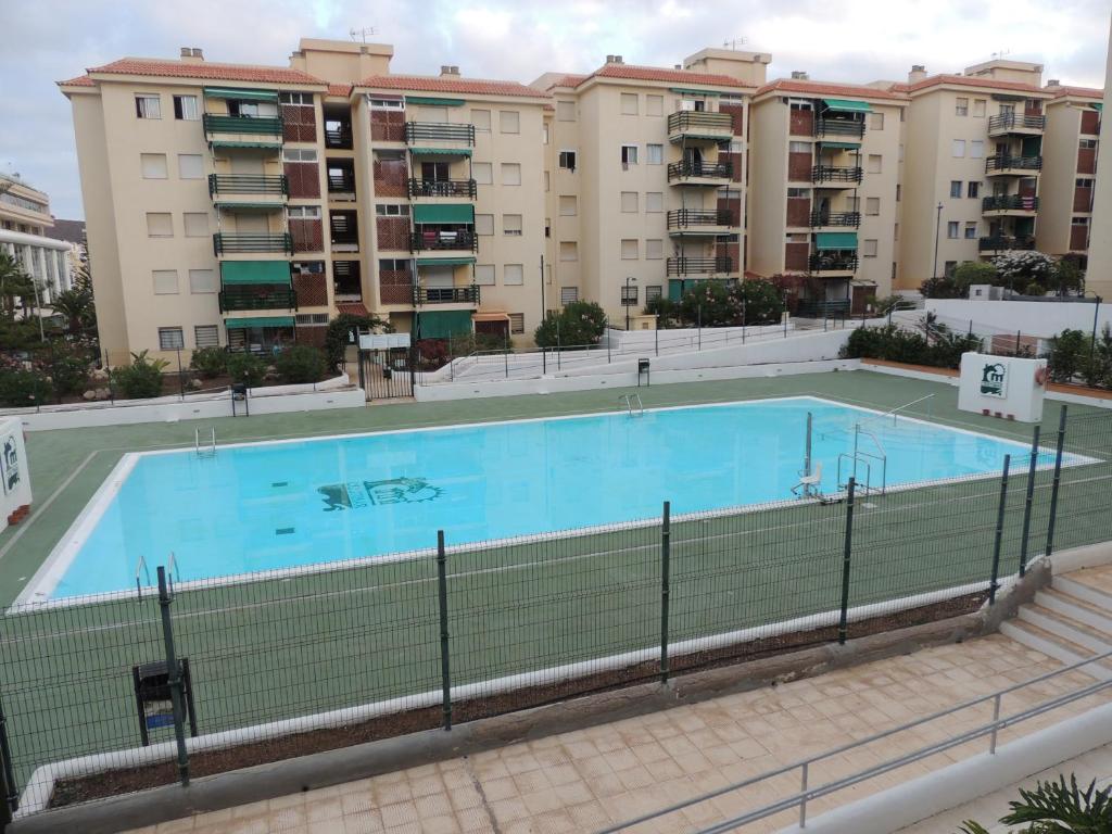 a swimming pool in front of some apartment buildings at Accessible Cristimar in Los Cristianos